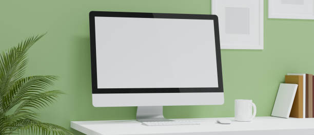 istock Comfortable working room with pastel green wallpaper, computer pc black screen mockup 1333888918