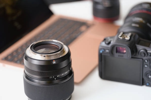 istock Lenses and camera lying on table near laptop closeup 1333889860