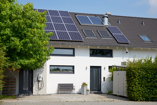 Grevenbroich, Germany - Aug. 04, 2021: Modern one-family house with solar panels and a car recharging station in the development area of Grevenbroich, North-Rhine Westphalia.
