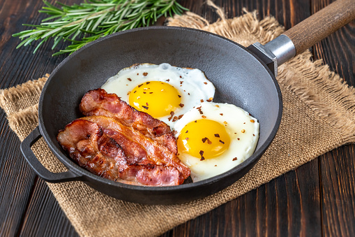 Fried eggs with bacon rashers  on the frying pan