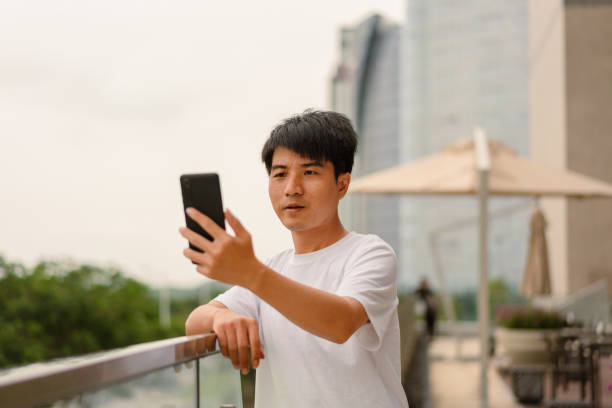 istock An Asian man uses a smartphone to take a selfie 1333897979