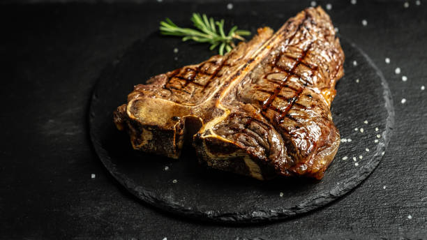 T-bone or aged wagyu porterhouse grilled beef steak with spices and herbs. Gourmet grilled and sliced porterhouse steak. Food recipe background. Close up stock photo