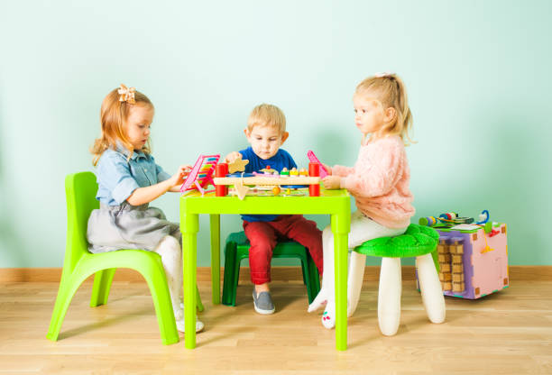 istock Children Sitting On Table With Toy 1333905103