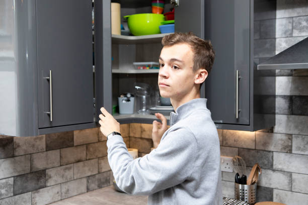 istock Male university student by an open a kitchen cabinet 1333907132