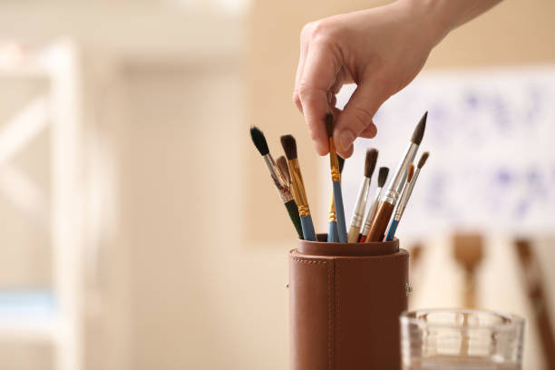 istock Watercolorist taking brush from holder in workshop, closeup. Space for text 1333907147