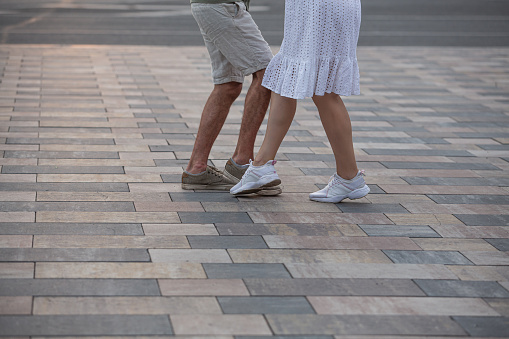 Couple dancing on street. legs of dancing people