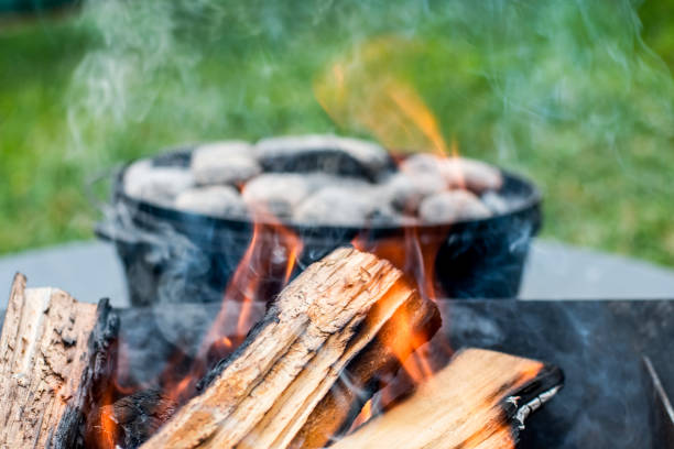 istock Dutch oven camp cooking with coal briquettes beads on top. Campfire 1333911283