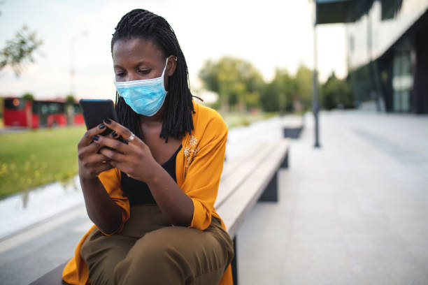 istock Black woman with protective face mask outside office building 1333914048