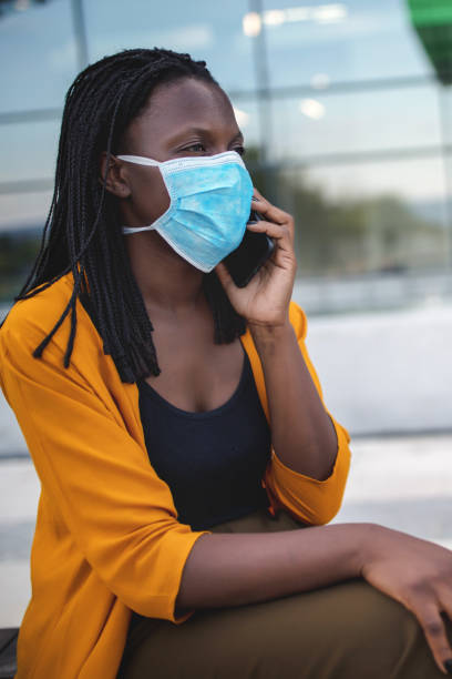 istock Black woman with protective face mask outside office building 1333914056