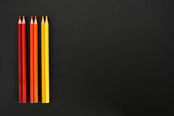istock Warm colored pencils on black background 1333914982