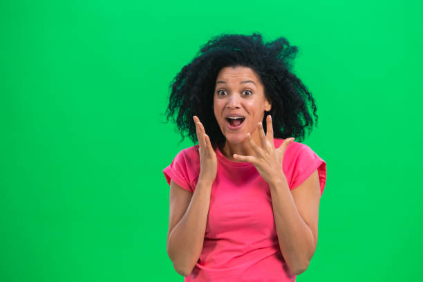 retrato de jovens afro-americanas olhando para a câmera com prazer e alegria. mulher negra com cabelo encaracolado em camiseta rosa posa na tela verde no estúdio. feche acima - chroma key fotos - fotografias e filmes do acervo