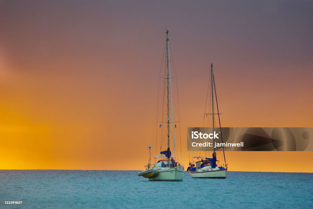 Dos yates en contra de la espectacular puesta de sol de oro - Foto de stock de Agua libre de derechos