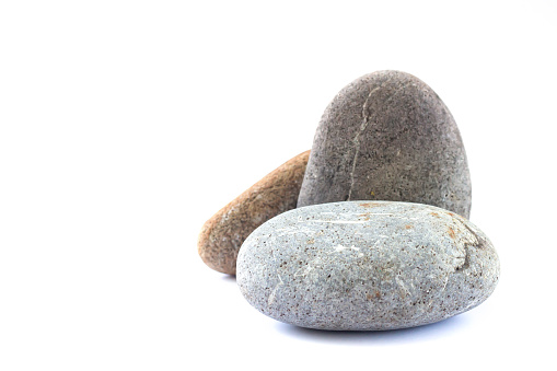 Stone podium or platform for cosmetic products or other object. Pebbles isolated on white background
