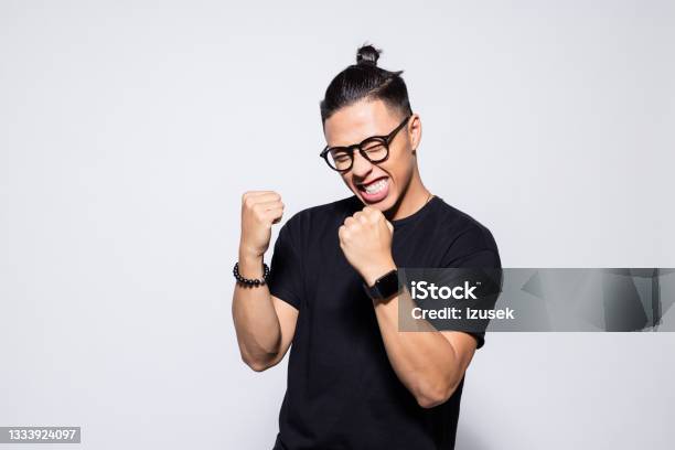 Excited Asian Young Man In Black Clothes Stock Photo - Download Image Now - Men, Winning, Happiness