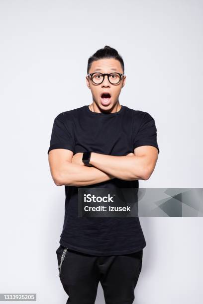 Surprised Asian Young Man In Black Clothes Stock Photo - Download Image Now - Arms Crossed, Nerd, 20-24 Years