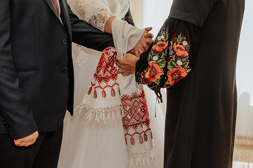 https://media.istockphoto.com/id/1333926340/photo/newlyweds-are-tied-a-white-towel-with-a-national-ornament-on-their-hands-together.jpg?b=1&s=170667a&w=0&k=20&c=GxGk0ifDQH_8IlbikqUSDt1aoDvmqqcBJD-NdxJu2MM=
