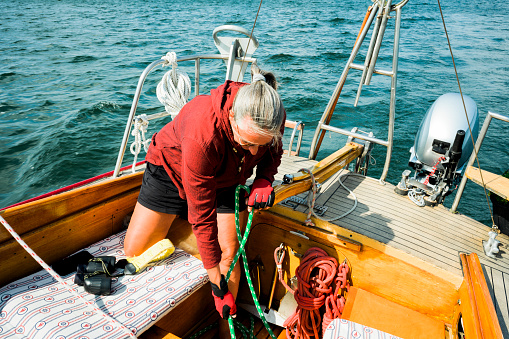 Active mature skipper woman sailing her sailboat, Germany, adventure, remote location, Mecklenburg-Vorpommern