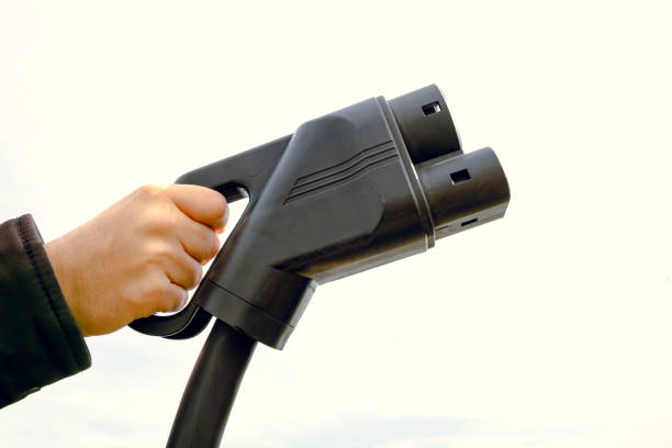 istock Man holding a DC fast car charger in focus 1333927425