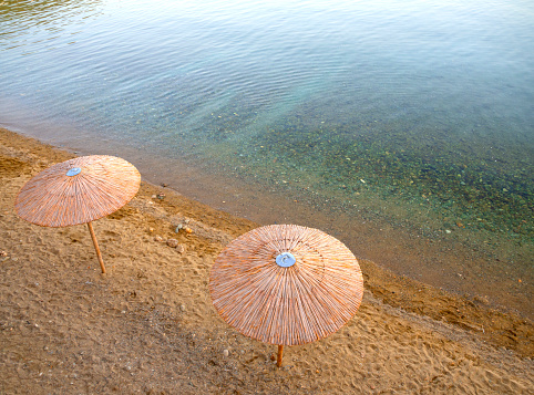 Beach reed umbrellas on the beach on the Greek island of Evia in Greece