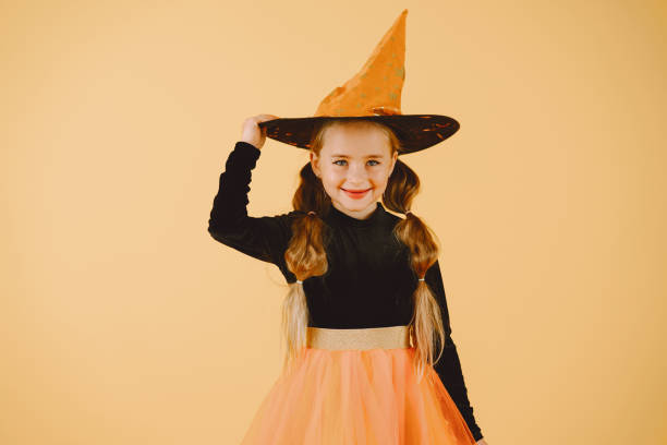 istock Beautiful girl witch on a orange background 1333927610