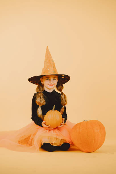 istock Beautiful girl witch on a orange background 1333927721