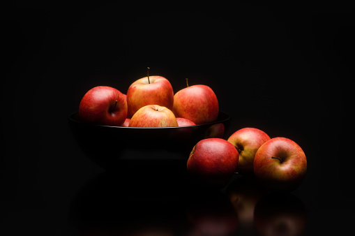 Digitally generated red delicious apples in a black bowl, isolated on black background.\n\nThe scene was created in Autodesk® 3ds Max 2022 with V-Ray 5 and rendered with photorealistic shaders and lighting in Chaos® Vantage with some post-production added.