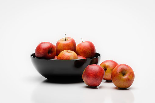 Digitally generated red delicious apples in a black bowl, isolated on white background.\n\nThe scene was created in Autodesk® 3ds Max 2022 with V-Ray 5 and rendered with photorealistic shaders and lighting in Chaos® Vantage with some post-production added.