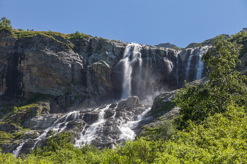 Waterfall and meltwater lake in the valley below Briksdal Glacier in Norway.