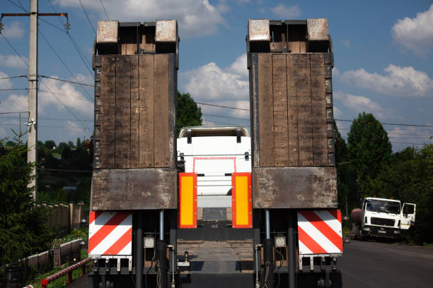 Fixed low loader trawl. Truck carries special equipment. Low loader trawl on the road. Freight transport. road machinery transportation on a truck. Fixed low loader trawl. Truck carries special equipment. Low loader trawl on the road. road machinery transportation on a truck. Freight transport. tow truck platform Hauling Trailers for heavy construction machineries stock pictures, royalty-free photos & images