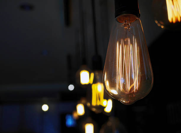 istock Vintage style light bulbs hanging on ceiling. Decorative lights. Old Edison bulb. 1333939479
