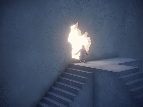 Woman climbed up the stairs and going through the bright light streaming from the crack in the wall. Can be used big idea, innovation, leadership concepts.  (3d render)