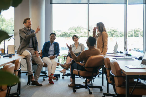 groupe de gens d’affaires souriants lors d’une réunion occasionnelle dans leur entreprise - cinq personnes photos et images de collection