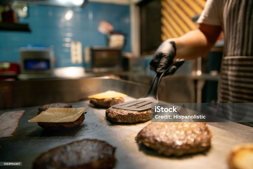 Close-up on a chef preparing burgers at a restaurant Close-up on a chef preparing burgers at a restaurant â fast food concepts Fast Food Restaurant Stock Photo