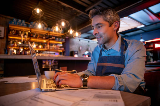 istock Manager working at a restaurant and doing the bookkeeping using his laptop 1333944308