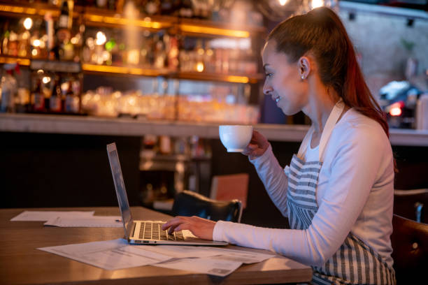 istock Business owner working at a restaurant and paying bills while drinking coffee 1333944320