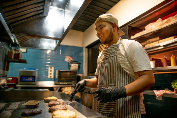 Happy chef at a restaurant preparing hamburgers