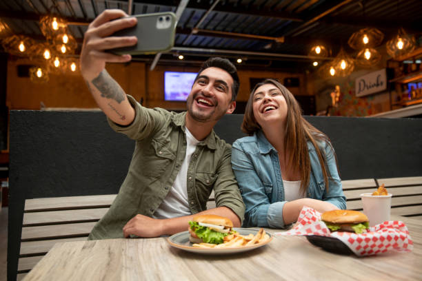 istock Happy couple taking a selfie while eating at a restaurant 1333944347