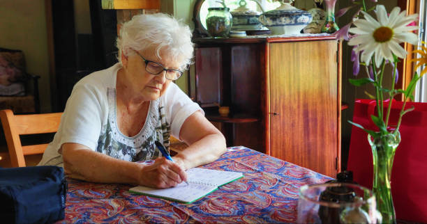 istock Senior female writing down blood pressure data in her diary 1333944457