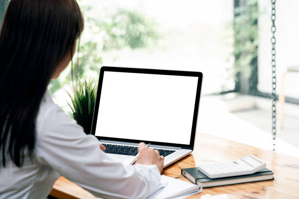 istock Young businesswoman working on laptop computer at office. Blank screen for graphic design. 1333946205