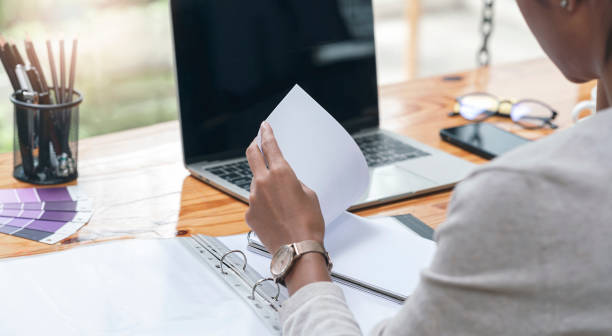 istock Cropped shot of woman hand working with document while sitting at office. 1333946224