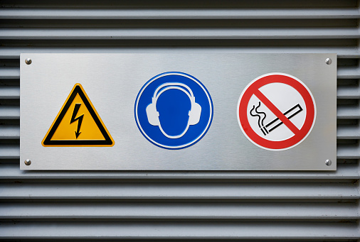 Warning signs /pictograms on a closed industrial door.