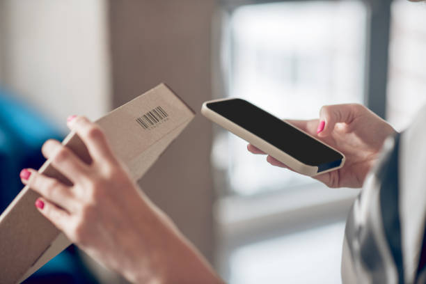 istock Internet shop worker scanning information on the product package 1333948633