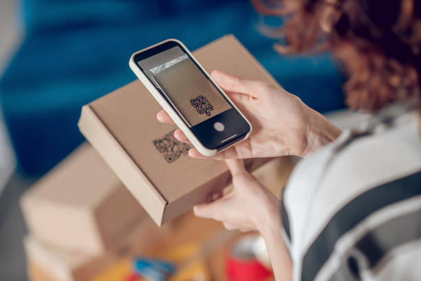 Online shop worker scanning information on the product package