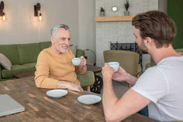 istock Two men sitting at the table, having tea and talking 1333958398