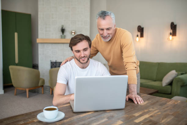 istock Two men watching something on a laptop and looking involved 1333958428