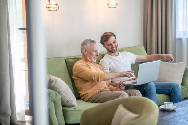 istock Young man and his dad watching something online and looking involved 1333958438