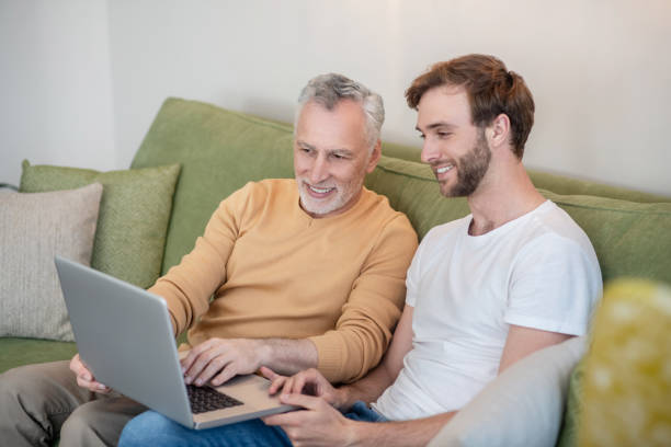 istock Young man and his dad watching something online and looking involved 1333958481