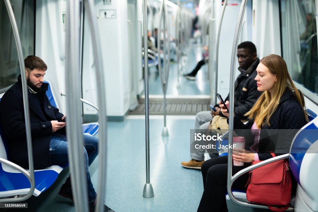 People in metro train Portrait of different adult people in warm overcoats during trip in metro train Subway Stock Photo