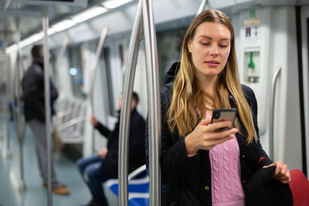istock Girl using mobile phone in metro car 1333958574