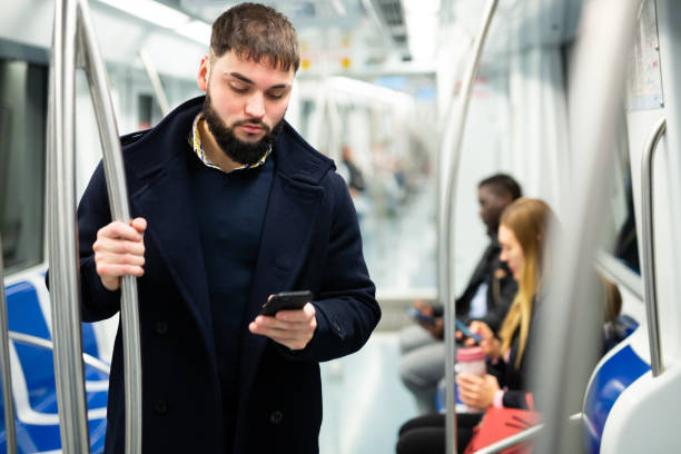 istock Young man with phone in metro car 1333958585